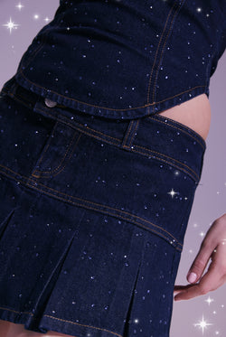 Displays a model wearing the Disney 'Juicy' branded denim diamanté scatter pleated skirt