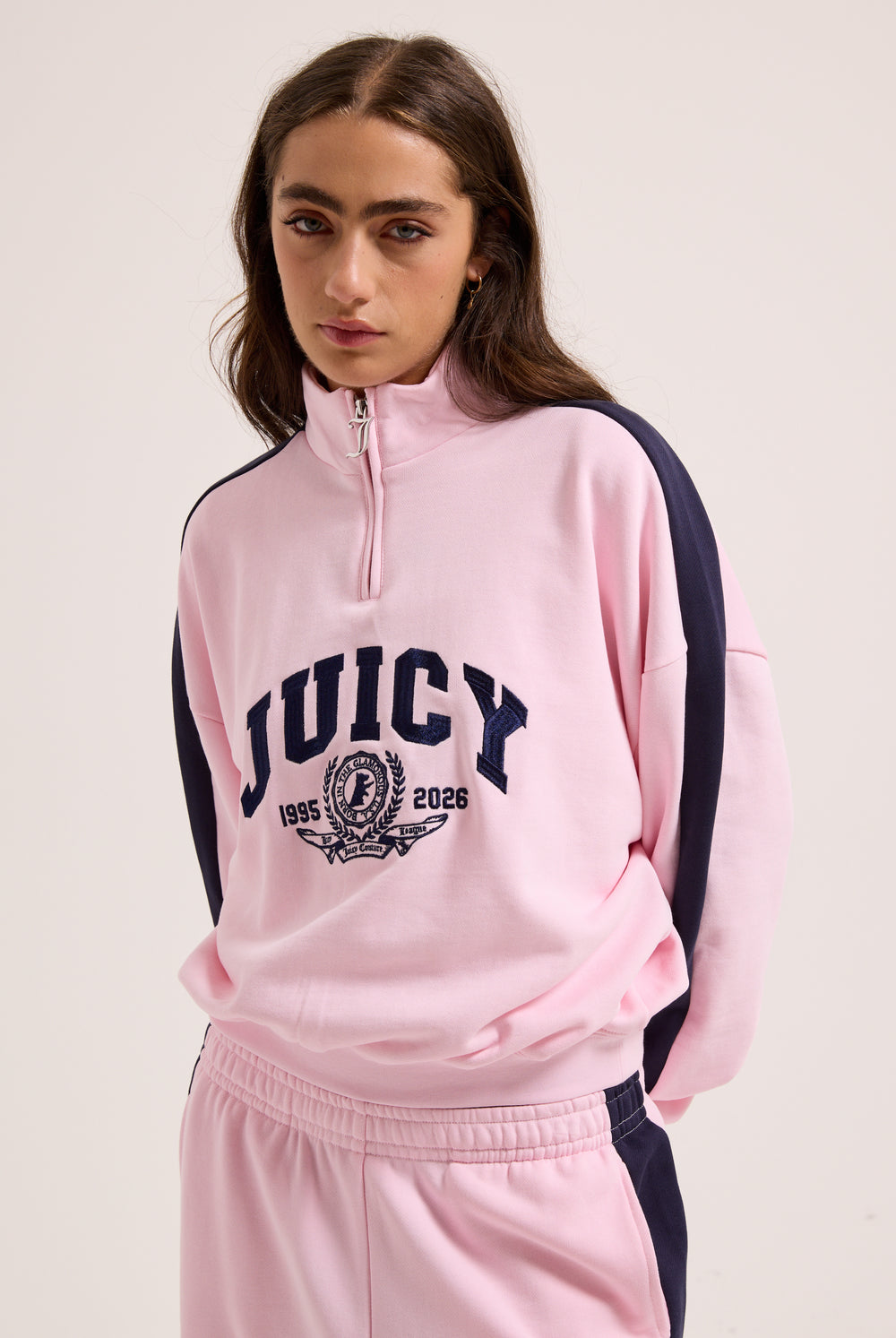 Displays a model wearing the Cherry Blossom 'Juicy' branded college crest track top  