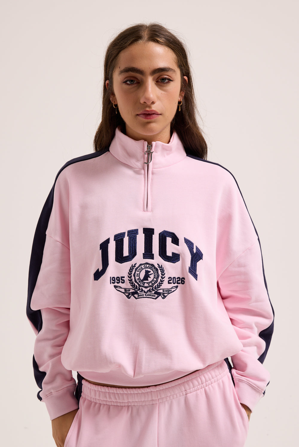 Displays a model wearing the Cherry Blossom 'Juicy' branded college crest track top  