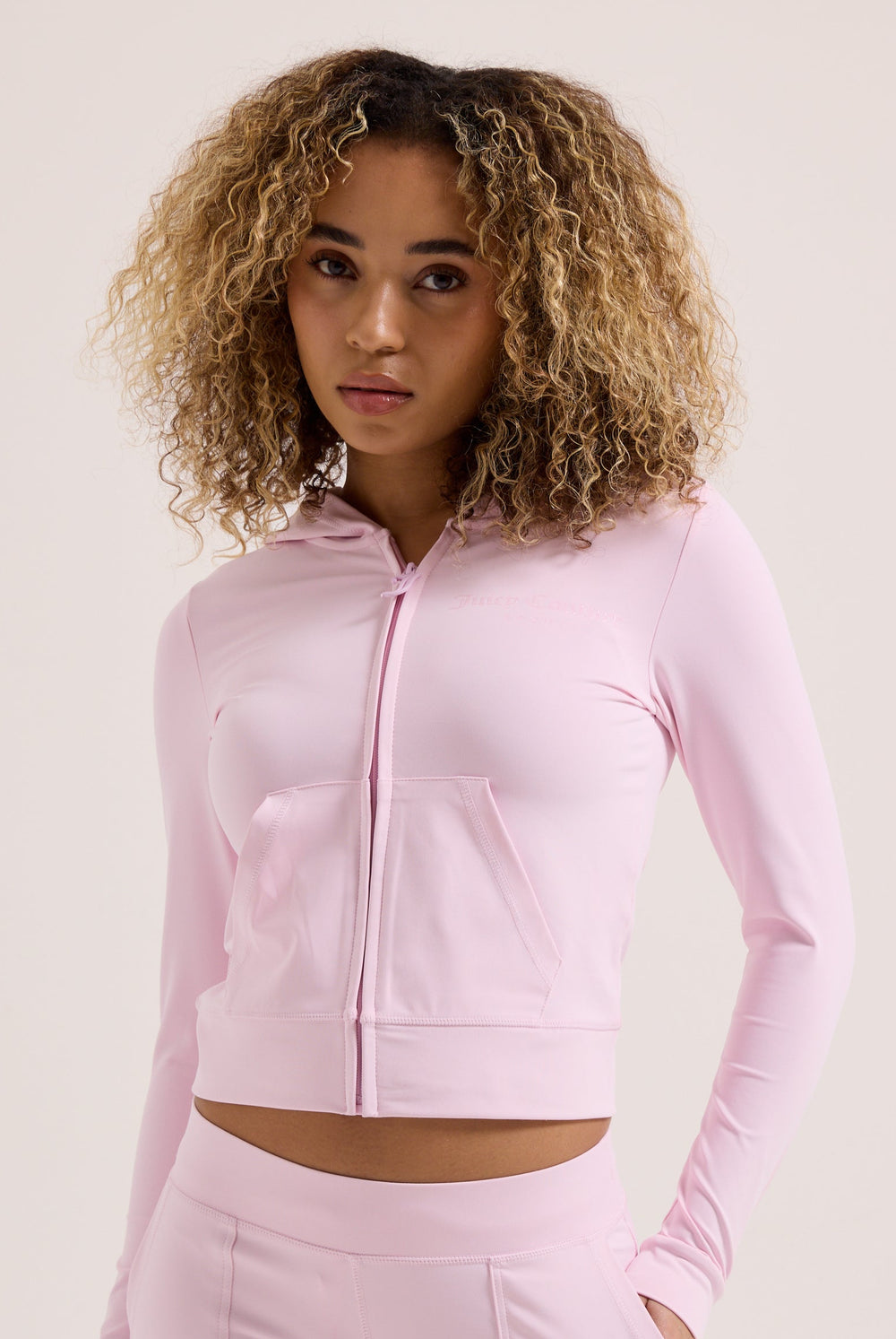 Displays a model wearing the Cherry Blossom peached 'Juicy' branded active fitted hoodie 