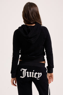 Displays a model wearing the Black appliqué 'Juicy' branded Terry ultra low straight track pants 