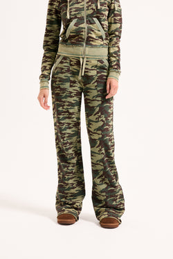 Displays a model wearing the Camo Print 'Juicy' branded washed cotton low rise track bottoms