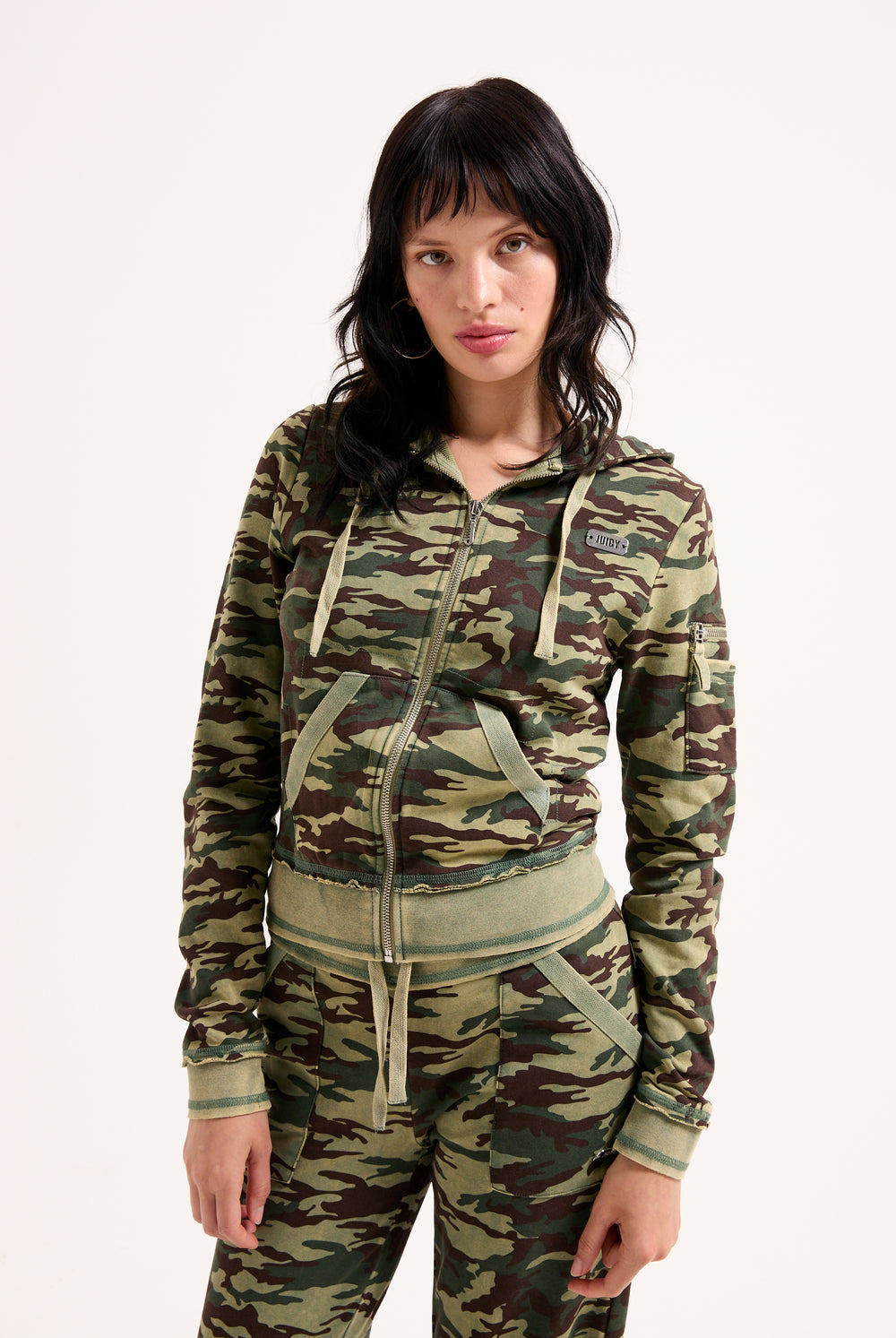 Displays a model wearing the Camo Print 'Juicy' branded washed cotton hoodie 