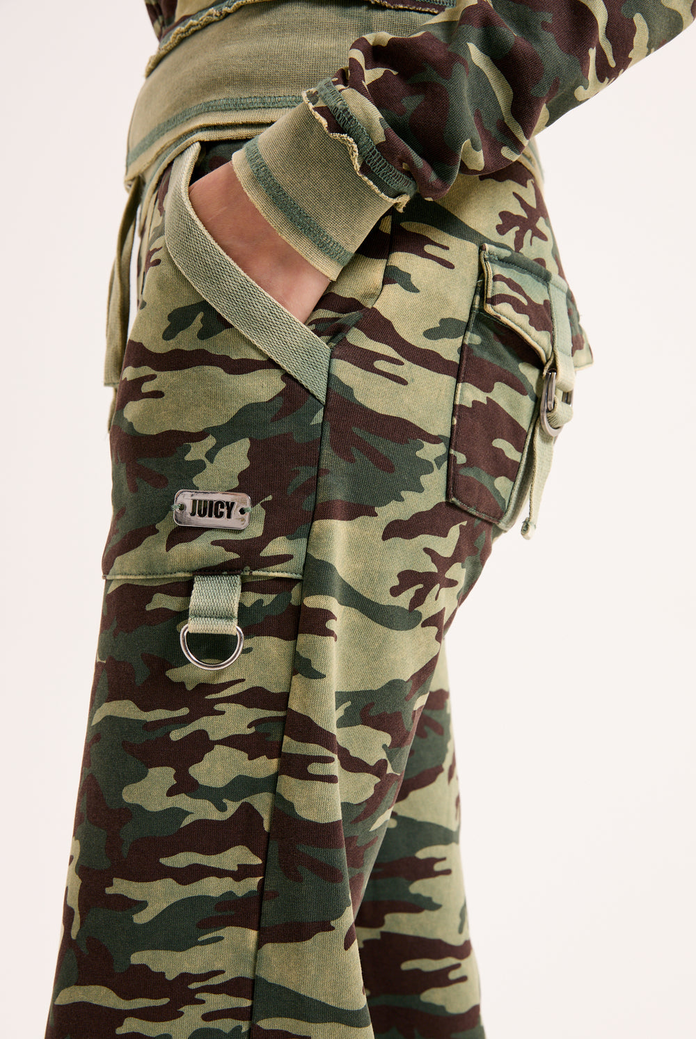 Displays a model wearing the Camo Print 'Juicy' branded washed cotton low rise track bottoms