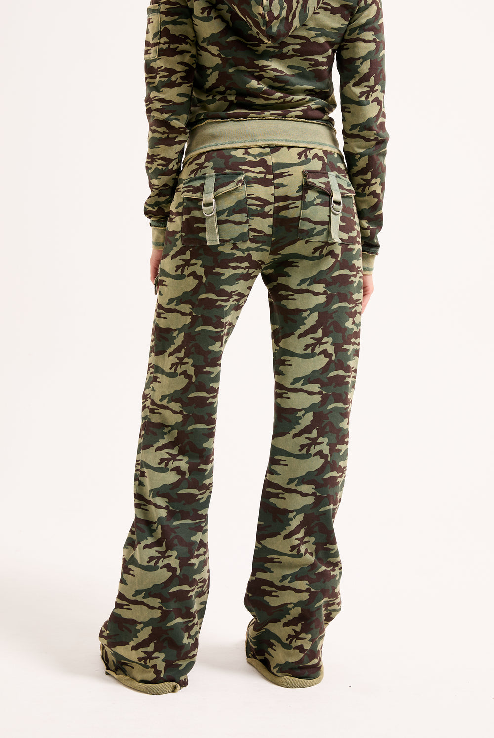 Displays a model wearing the Camo Print 'Juicy' branded washed cotton low rise track bottoms