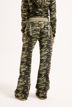 Displays a model wearing the Camo Print 'Juicy' branded washed cotton low rise track bottoms