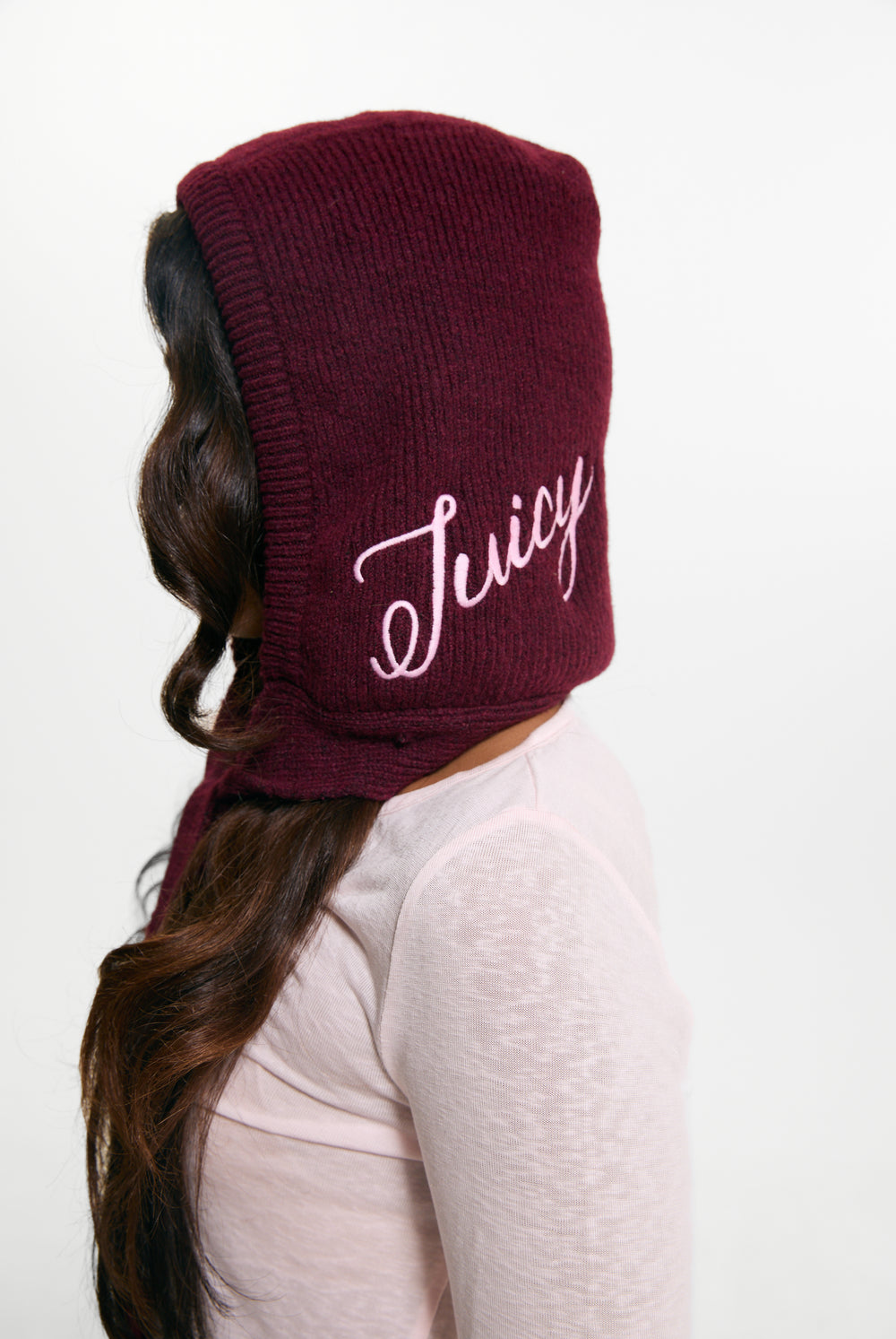 Displays a model wearing the Burgundy 'Juicy' branded Bonnet With Bow