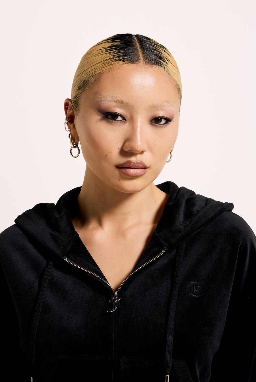 Displays a model wearing the Black 'Juicy' branded crop oversized classic velour hoodie 