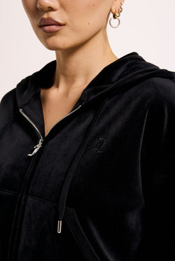 Displays a model wearing the Black 'Juicy' branded crop oversized classic velour hoodie 