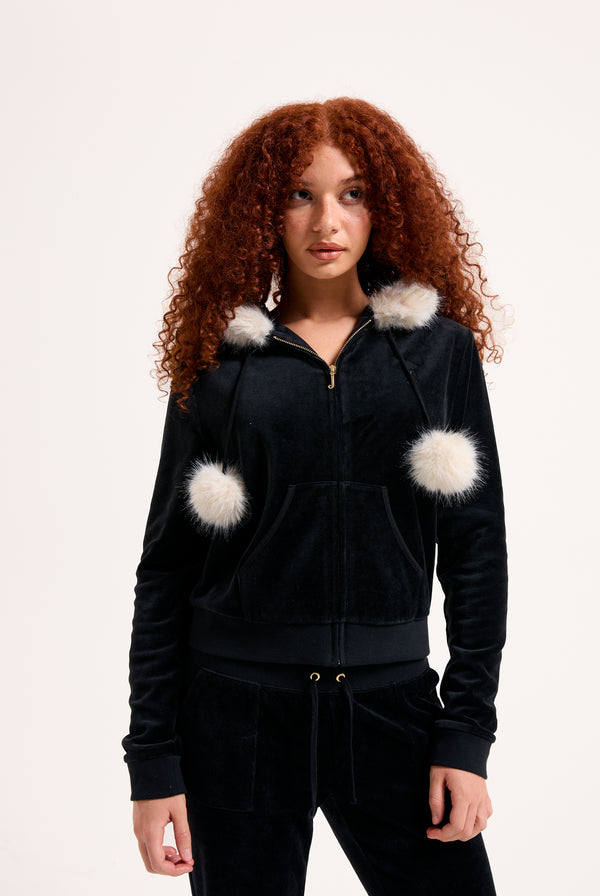 Displays a model wearing the Black 'Juicy' branded Pom Pom faux fur bamboo velour hoodie 