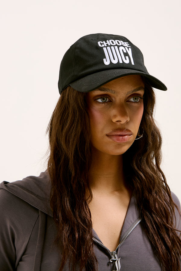 Displays a model wearing the Black 'Juicy' branded Choose Juicy cap 