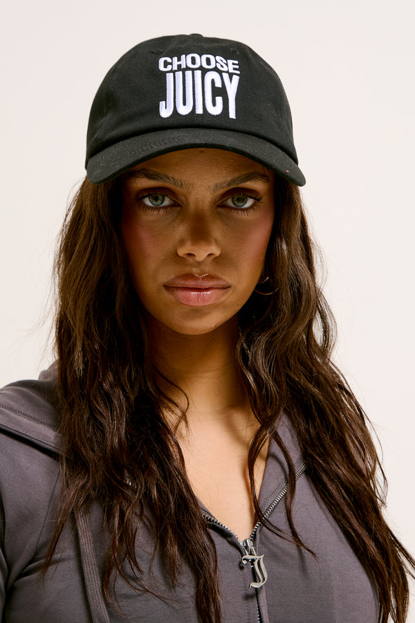 Displays a model wearing the Black 'Juicy' branded Choose Juicy cap 