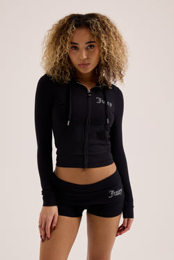 Displays a model wearing the Black 'Juicy' Branded Luxury Jersey Roll down Diamanté shorts with the matching Juicy top