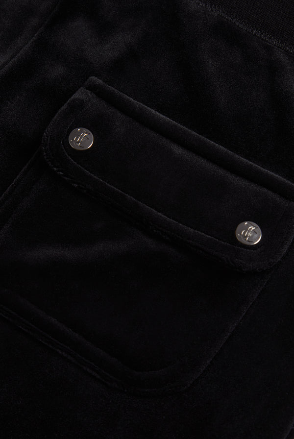 Close-up of the back pocket of black velour bottoms, showing the Juicy Couture branding on the buttons