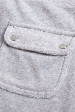 Close-up of the back pocket, showing a more detailed view of the Juicy Couture logo on the silver buttons