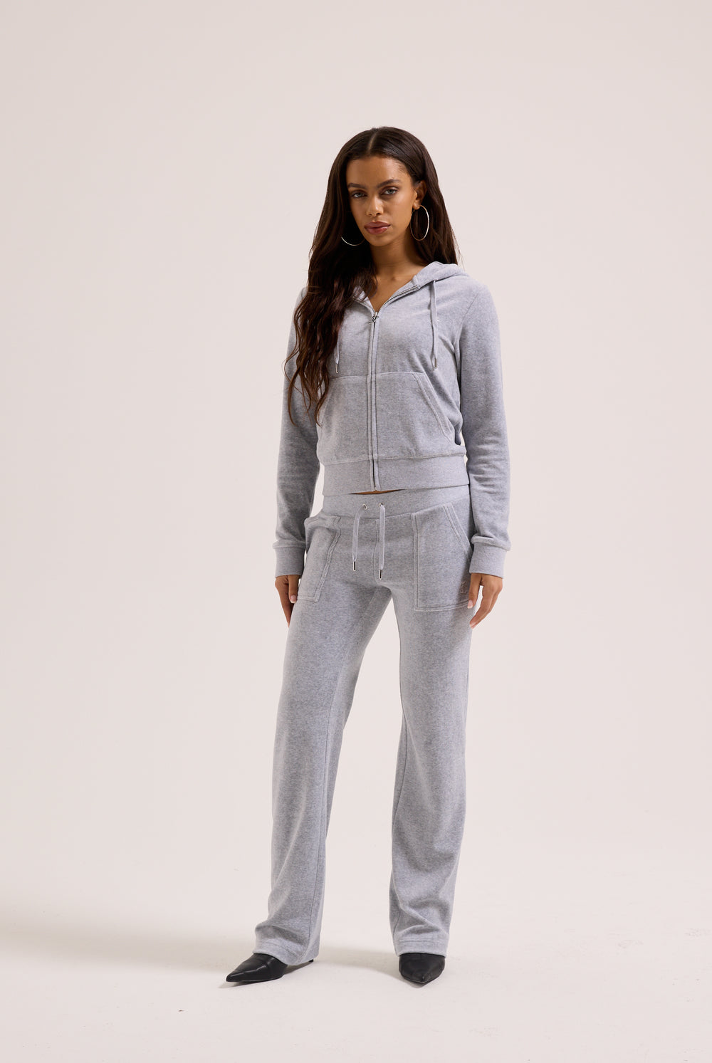 Woman wearing a gray tracksuit on a white background