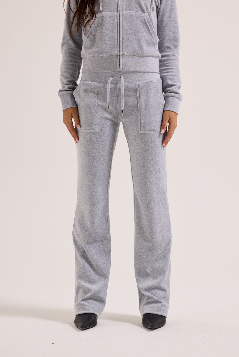 Person wearing a gray tracksuit on a white background