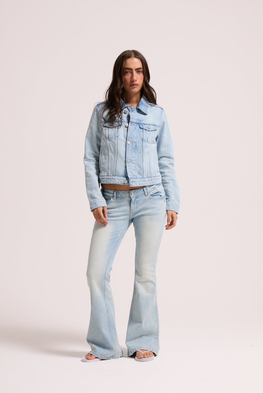 Displays a model wearing the light wash 'Juicy' branded Diamanté low rise flare jeans 