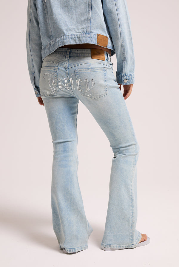 Displays a model wearing the light wash 'Juicy' branded Diamanté low rise flare jeans featuring the juicy branding 