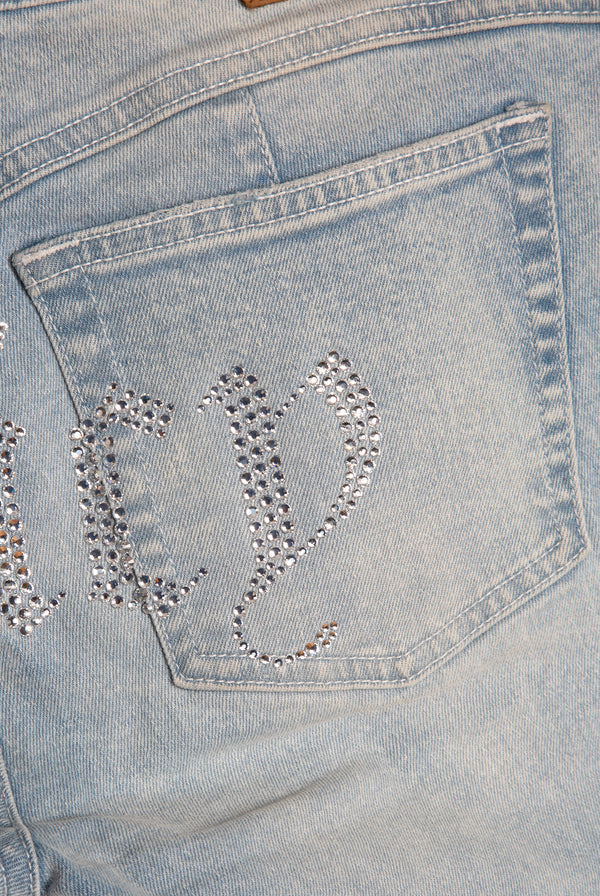 Displays he light wash 'Juicy' branded Diamanté low rise flare jeans featuring the juicy branding