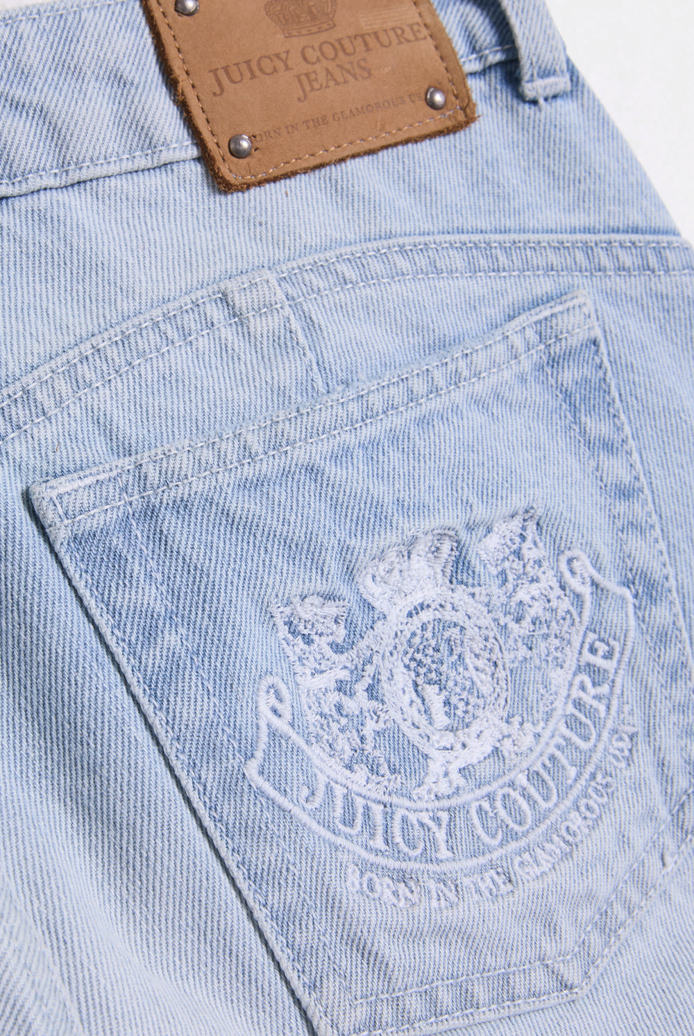 Displays he Light Wash 'Juicy' branded Dog crest bootcut jeans featuring the juicy logo