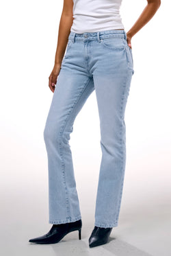 Displays a model wearing the Light Wash 'Juicy' branded Dog crest bootcut jeans