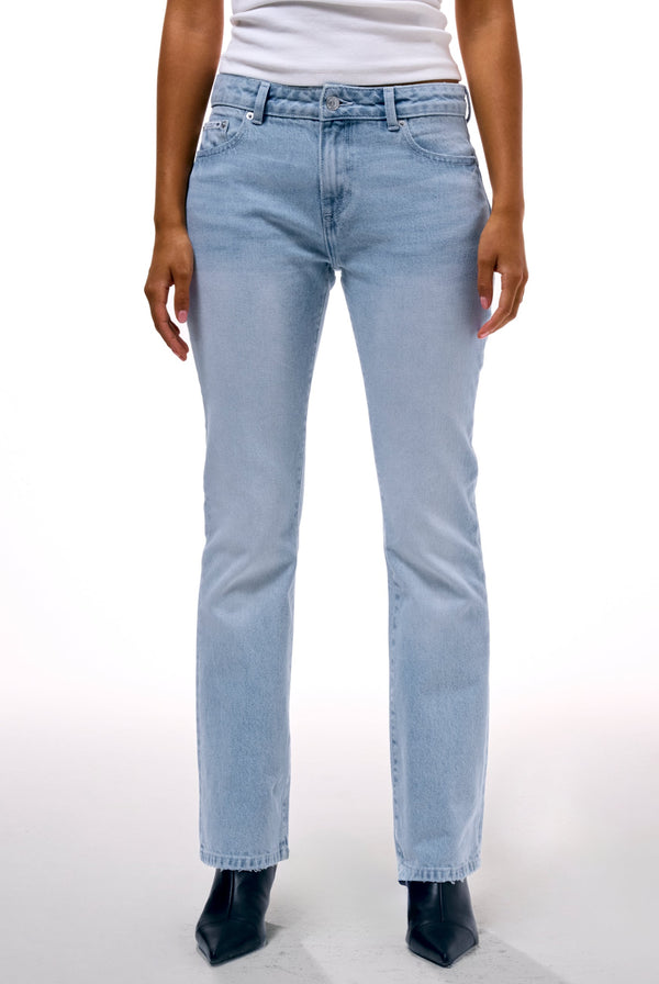 Displays a model wearing the Light Wash 'Juicy' branded Dog crest bootcut jeans