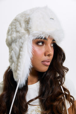 Displays a model wearing the Sugar Swizzle 'Juicy' branded Cable Knit Trapper With Fur Lining