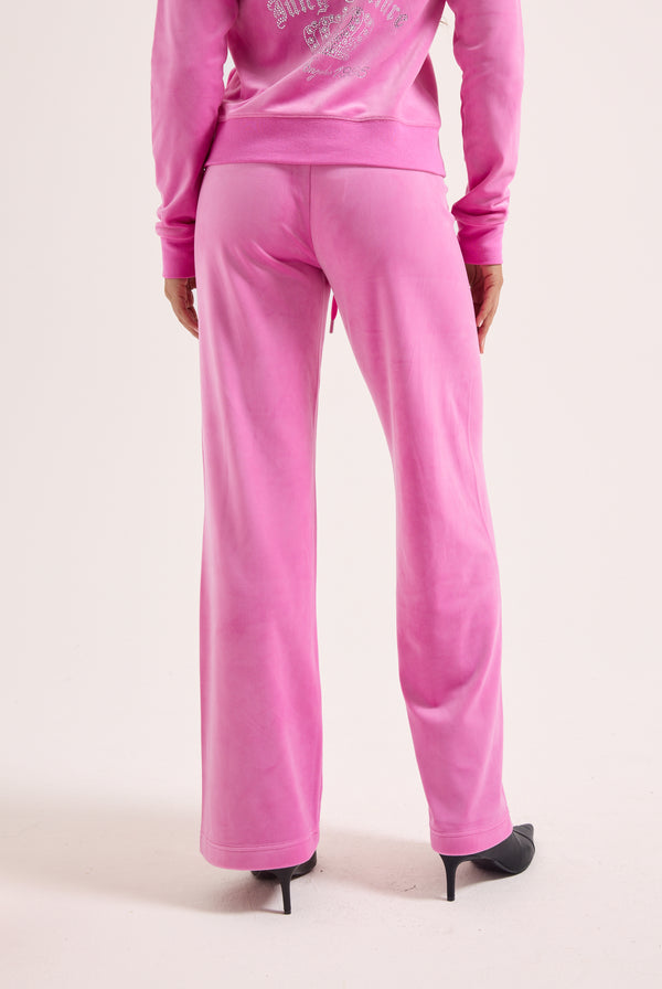 Displays a model wearing the super pink 'Juicy' branded diamanté crown OG straight low rise velour bottoms 