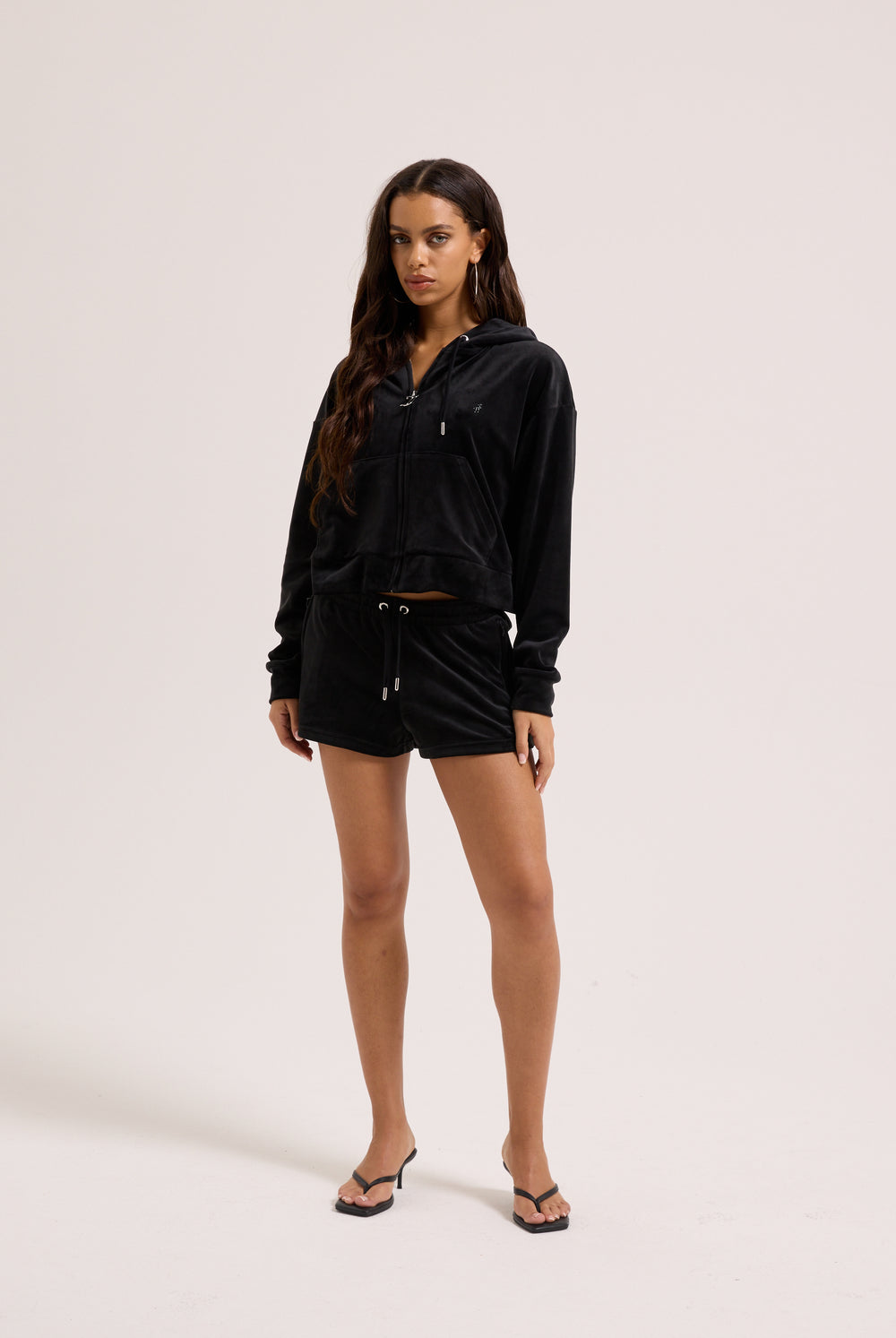 Displays a model wearing the Black outline 'Juicy' branded diamanté oversized cropped hoodie 