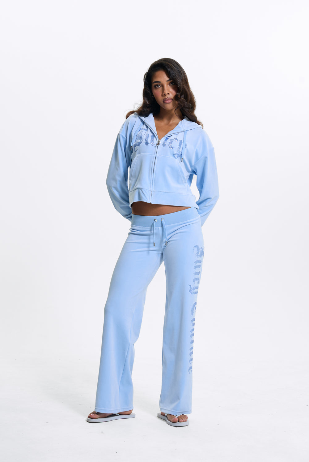 Displays a model wearing the Powder Blue 'Juicy' branded Old Gothic Diamante Og Straight Leg Trackpant