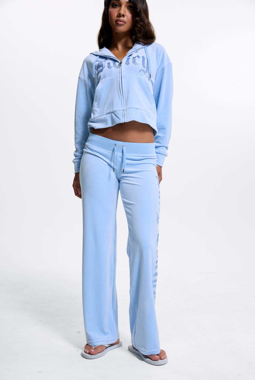 Displays a model wearing the Powder Blue 'Juicy' branded Old Gothic Diamante Og Straight Leg Trackpant