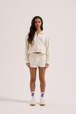 Displays a model wearing the Cream Outline 'Juicy' branded diamanté oversized cropped hoodie