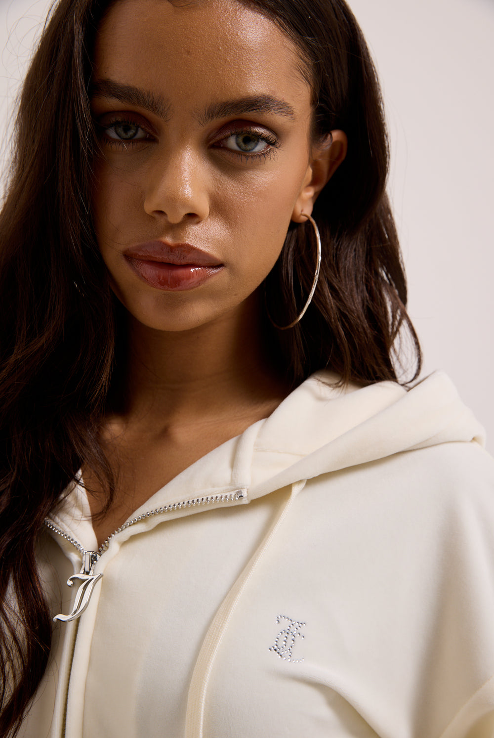 Displays a model wearing the Cream Outline 'Juicy' branded diamanté oversized cropped hoodie