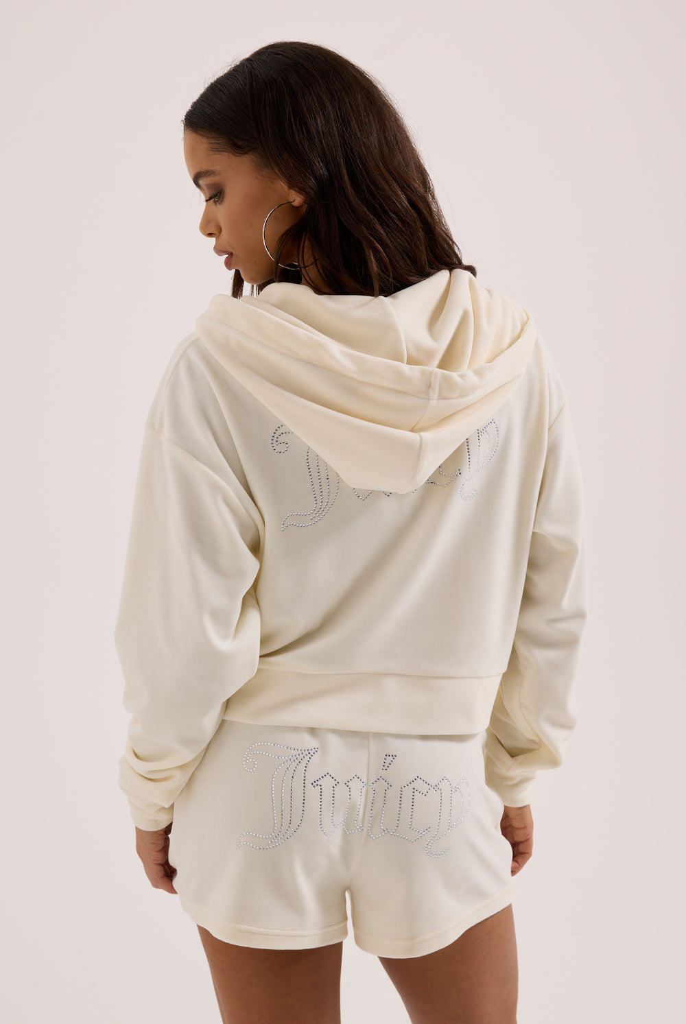Displays a model wearing the Cream Outline 'Juicy' branded diamanté oversized cropped hoodie
