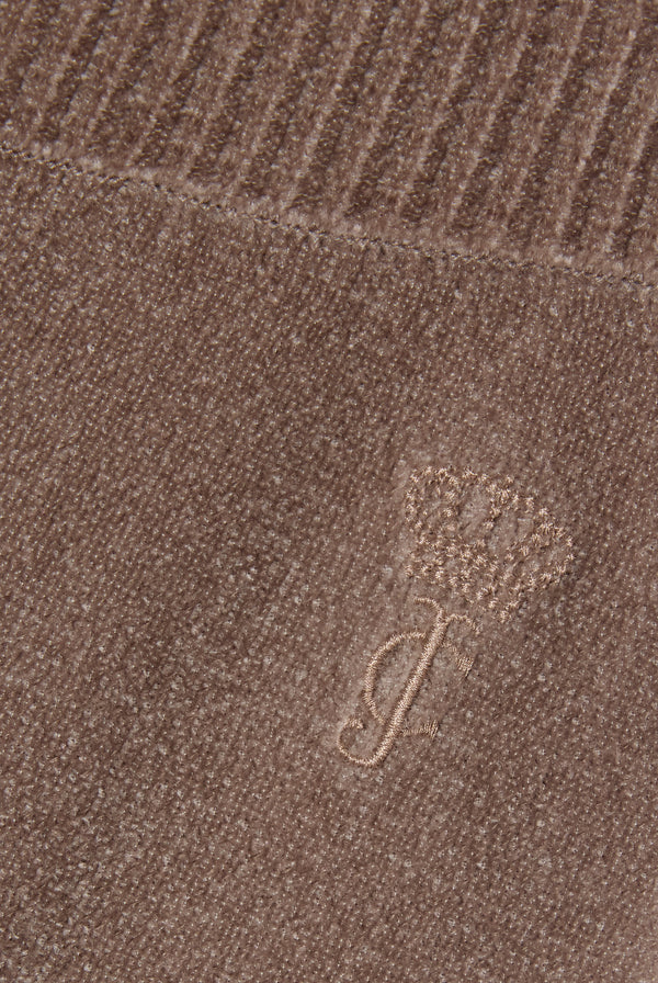 Displays a model wearing the String 'Juicy' branded luxe knit straight leg pant featuring the juicy branding 