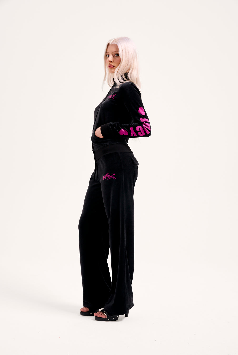 Displays a model wearing the Black 'Juicy' branded angel cotton velour track top