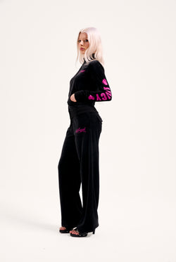 Displays a model wearing the Black 'Juicy' branded angel cotton velour track top