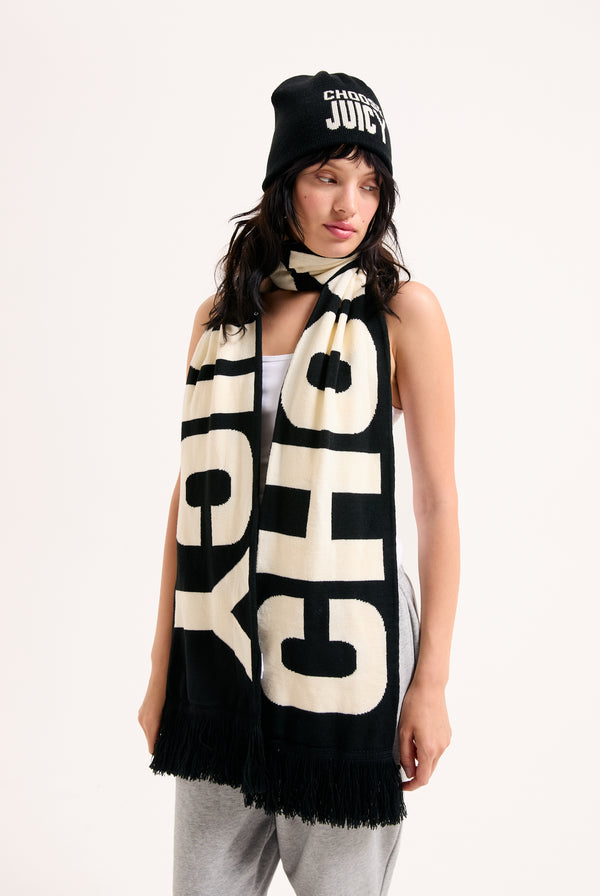 Displays a model wearing the 'Choose Juicy' knitted scarf and beanie included In the set 