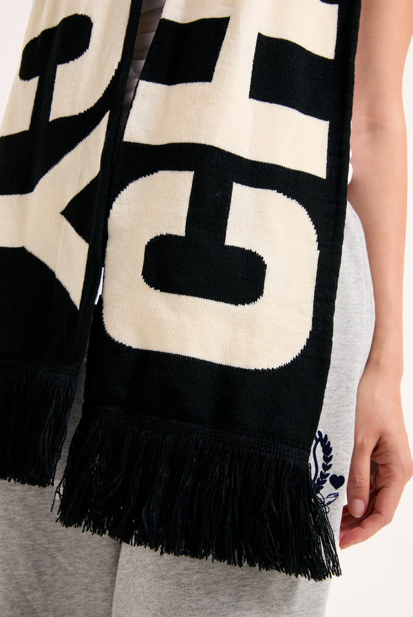Displays a model wearing the 'Choose Juicy' knitted scarf included in the set