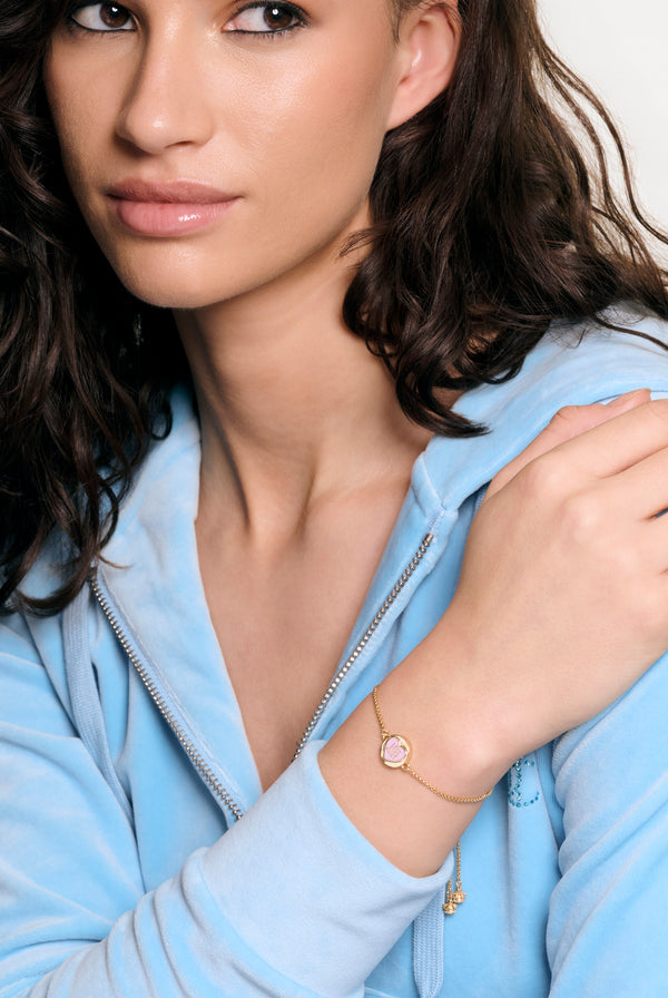 Displays a model wearing the Gold tone 'Juicy' branded love juicy reversible enamel adjustable bracelet 