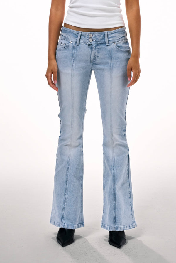 Displays a model wearing the Light wash 'juicy' branded low rise flared embodied jeans 