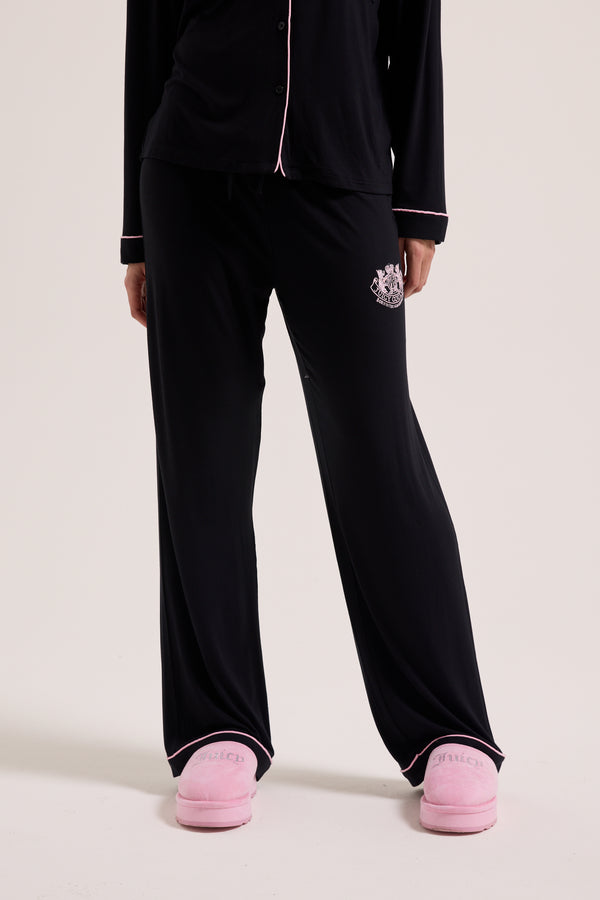 Displays a model wearing the Black 'Juicy' branded Juicy Dog crest pyjama set 