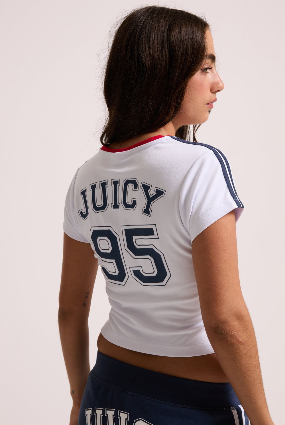 Displays a model wearing the White 'Juicy' branded Juicy Wag V Neck T-Shirt featuring the juicy 95 branding 