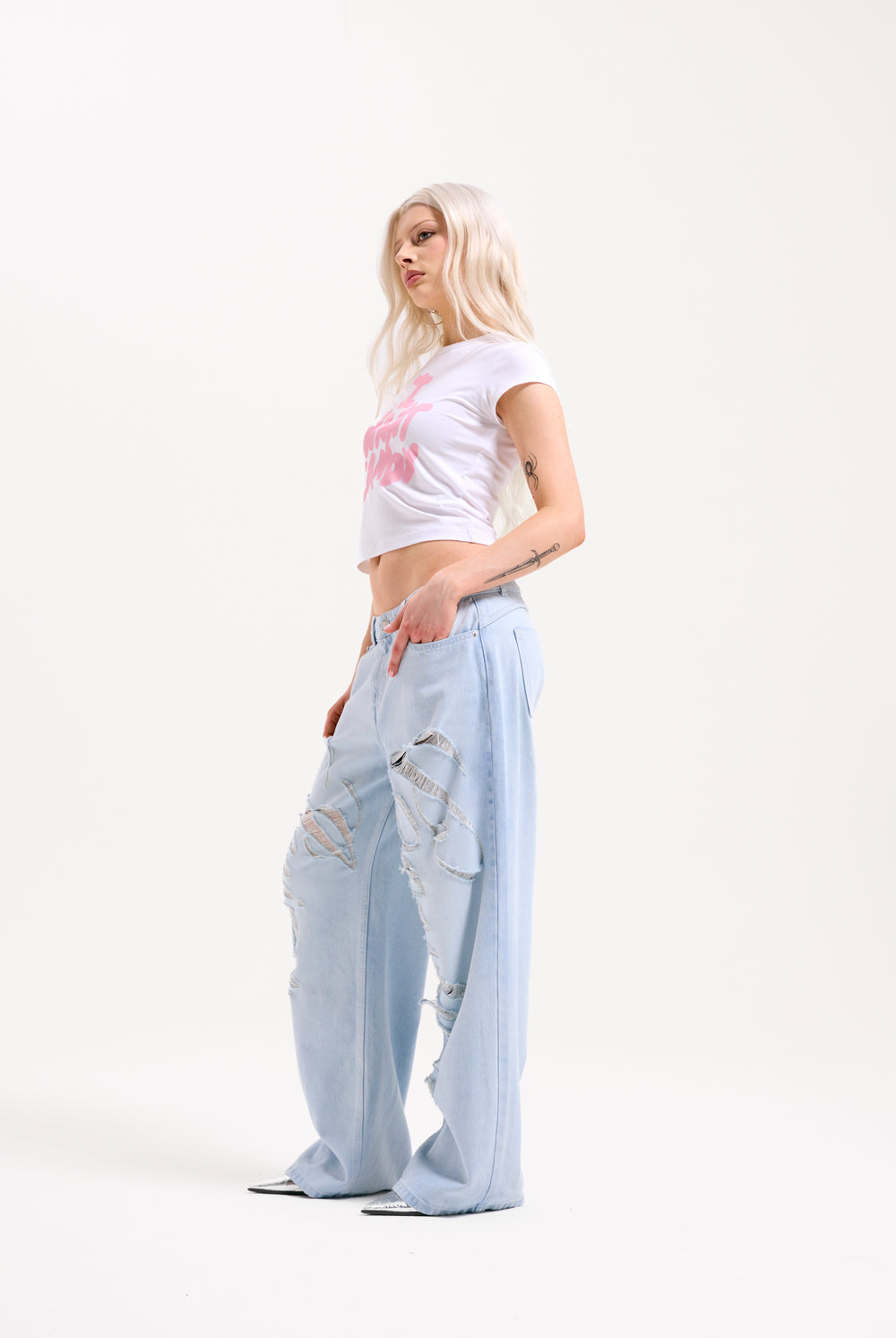 Displays a model wearing the Bleached 'Juicy' branded denim distressed wide leg jeans 