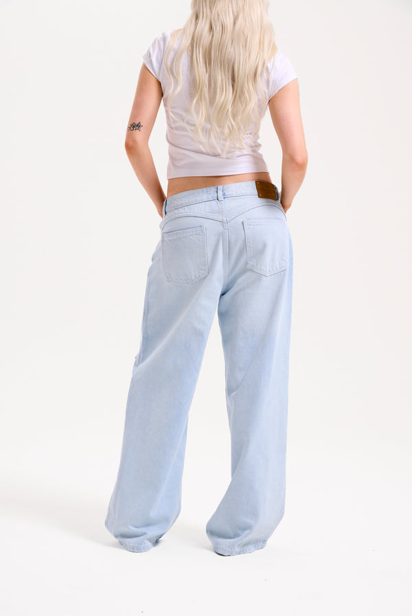Displays a model wearing the Bleached 'Juicy' branded denim distressed wide leg jeans 