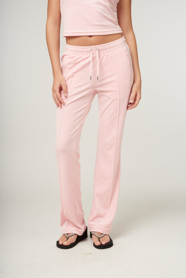 Displays a model wearing the Almond Blossom 'Juicy' branded velour diamanté tracksuit bottom 