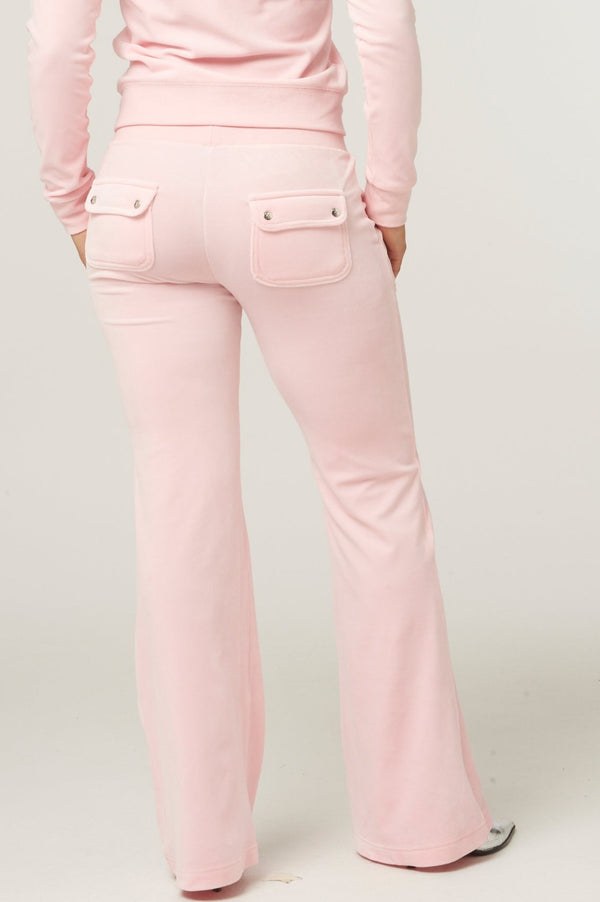 Displays a model wearing the almond blossom 'Juicy' branded low rise flare classic velour track pant 