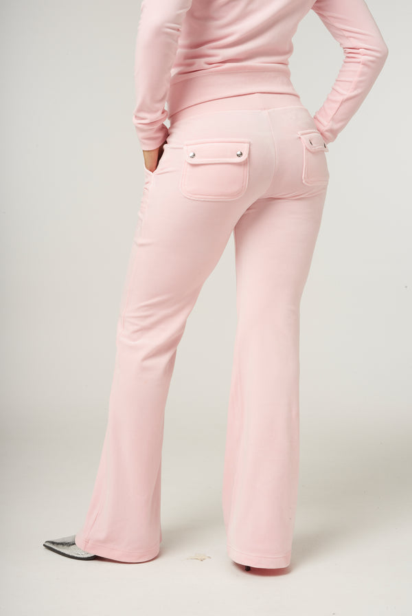 Displays a model wearing the almond blossom 'Juicy' branded low rise flare classic velour track pant 