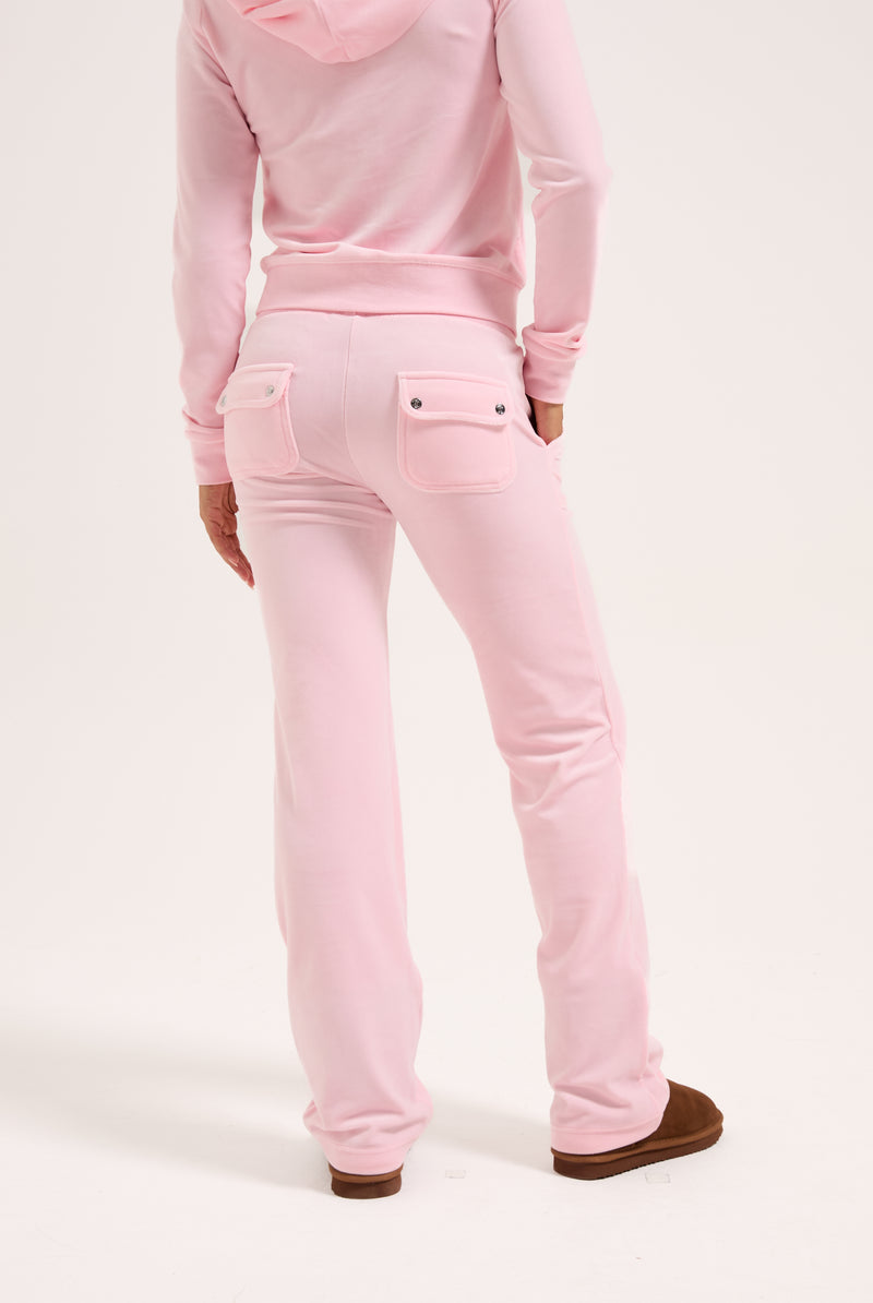 Displays a model wearing the Almond Blossom 'Juicy' branded classic velour del ray pocketed bottoms 
